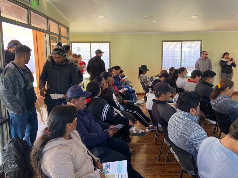 Personas migrantes participando de charla sobre Empadronamiento Biométrico en Huara