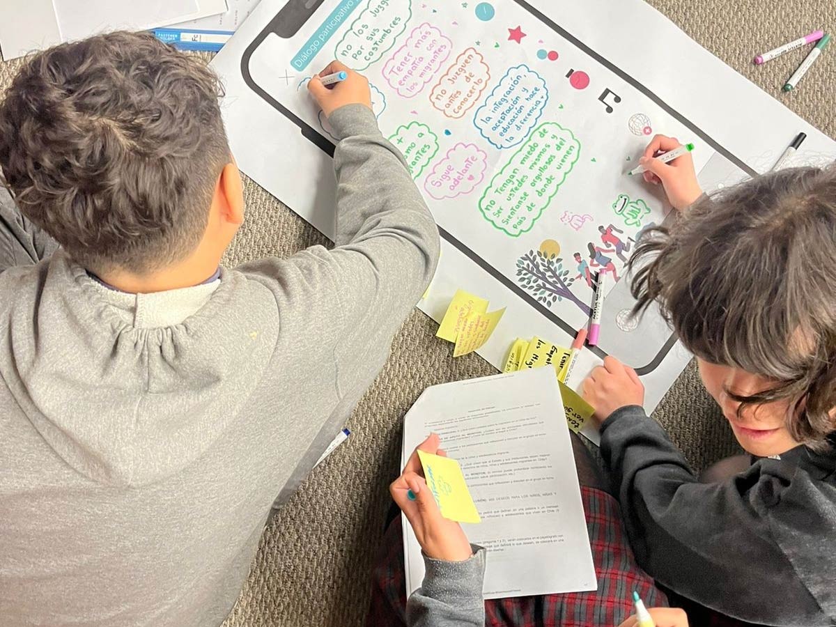 Niños, Niñas y Adolescentes escribiendo en jornada de participación SERMIG