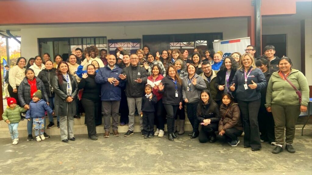 Grupo de mujeres que asisiteron a jornada de Apoya Mujer Migrante, posando junto al Director Regional del Maule