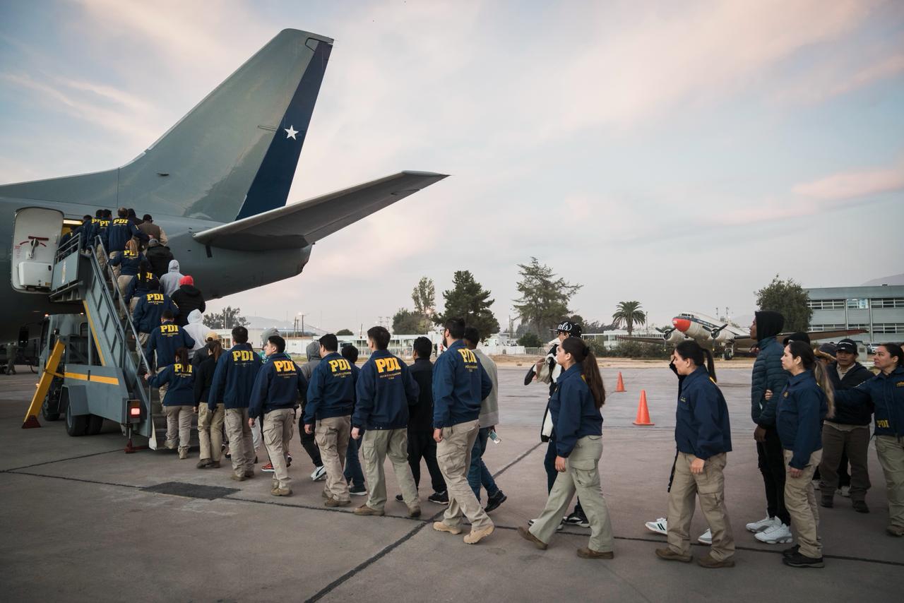 Extranjeros con orden de expulsión en fila embarcando el avión para regresar a su país.
