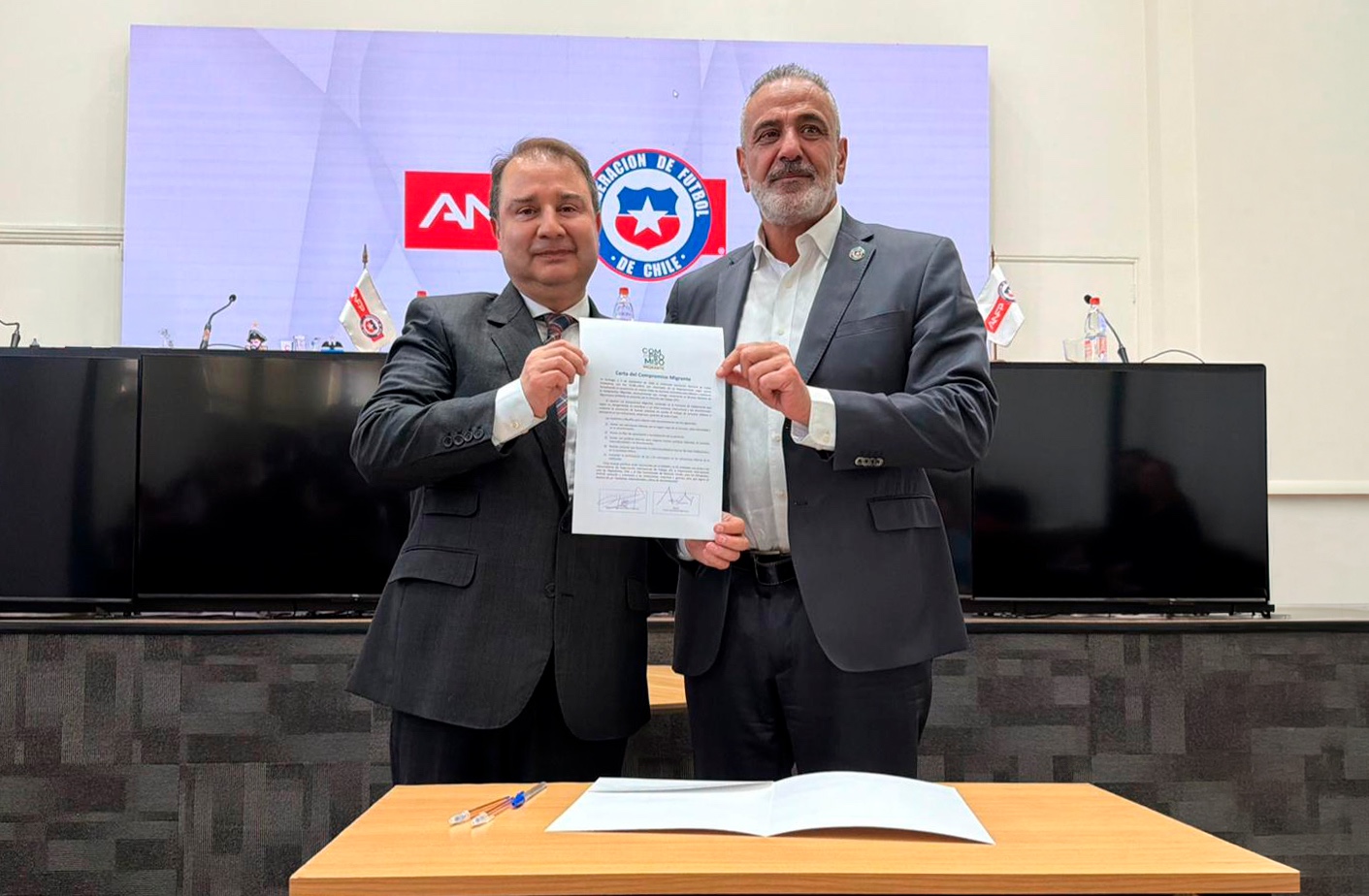 Director Nacional de Migraciones, Frank SAuerbaum, junto al Presidente de la Asociación Nacional de Fútbol de Chile, con la firma de Compromiso Migrante.